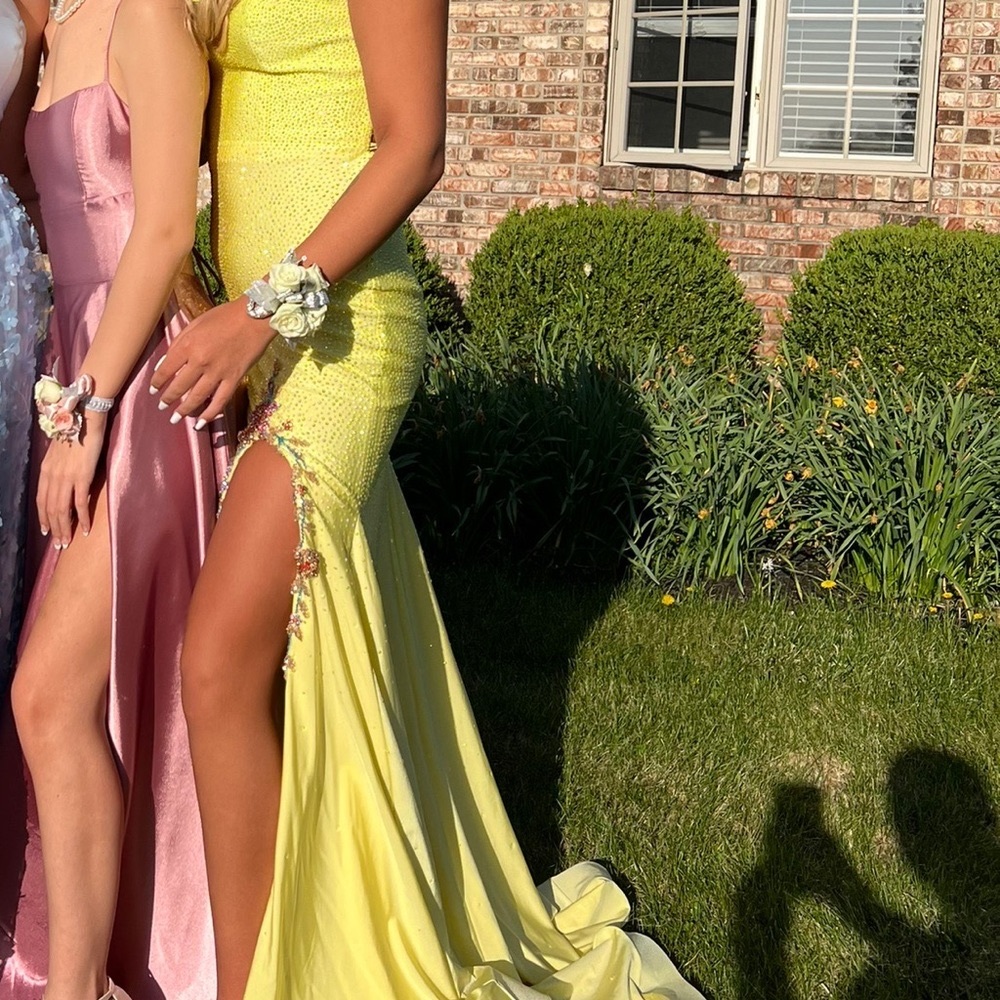 Pretty yellow prom dress with purple flower details on the slit. Size 6 Amarra